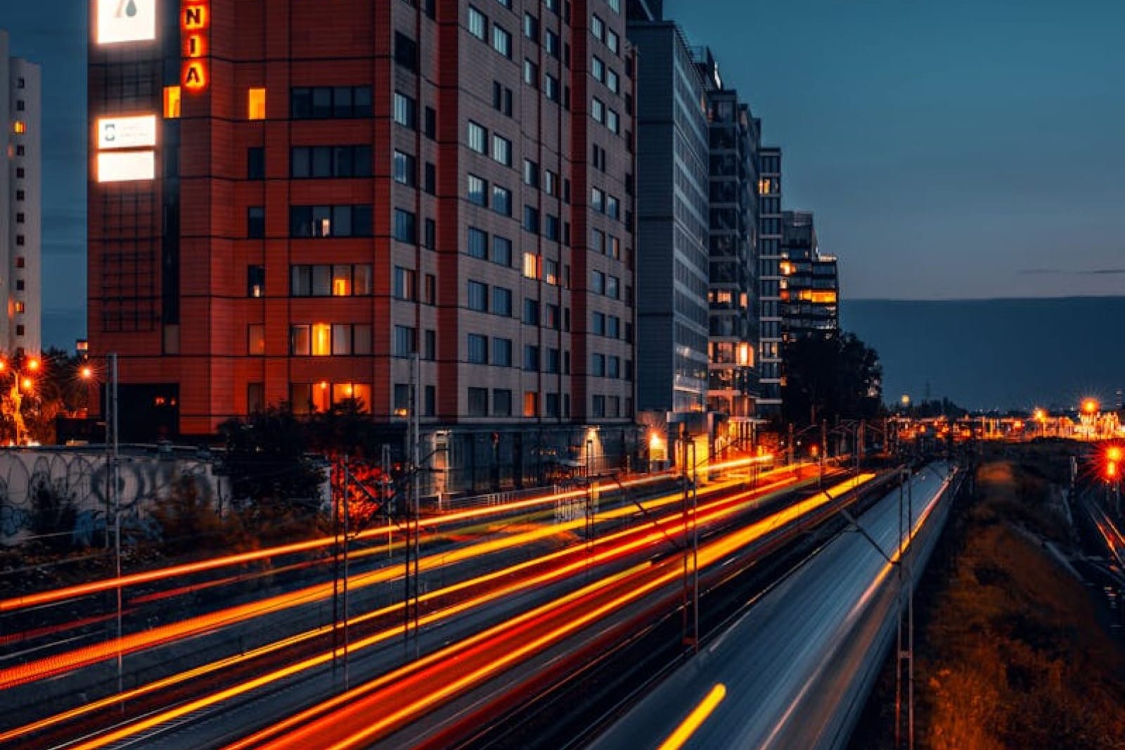 Dynamic night scene of Warsaw cityscape featuring light trails and modern architecture.