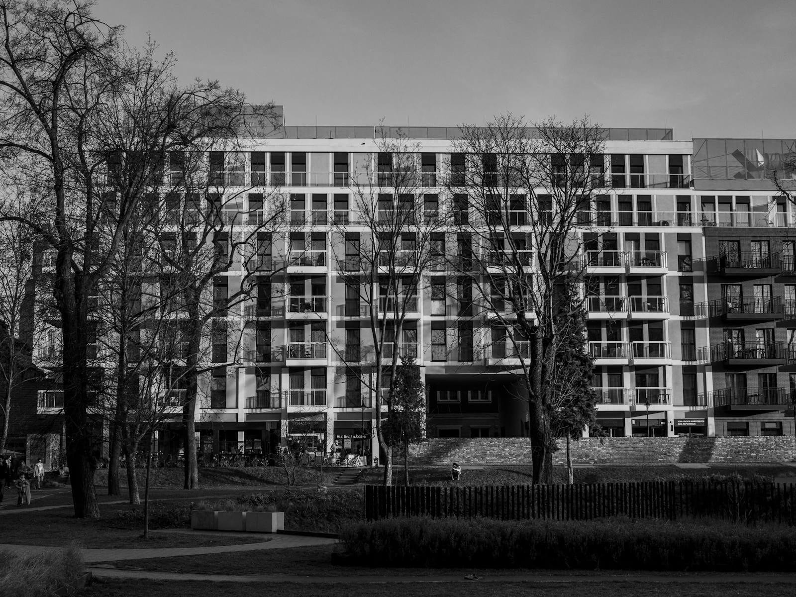 Monochrome view of a contemporary apartment building in a city park.