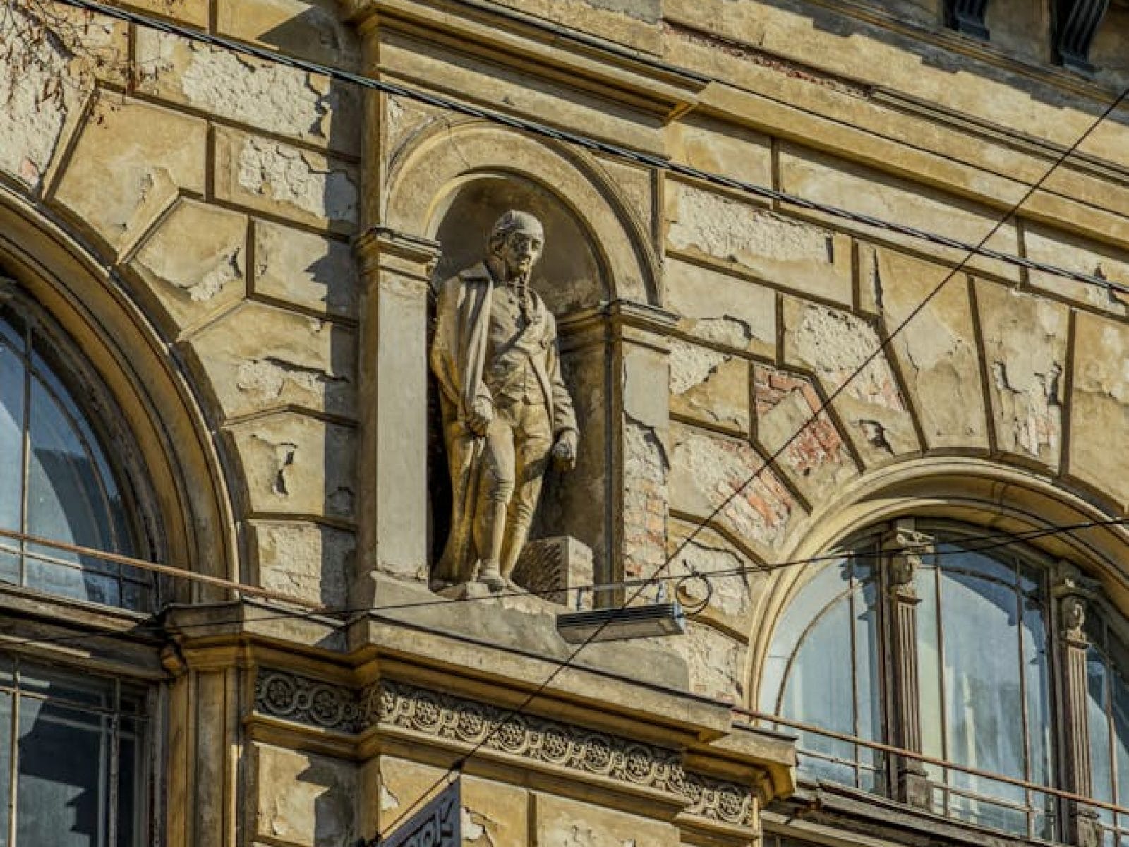 Close-up of a historic building facade with a statue in Lviv, Ukraine, under a clear blue sky.